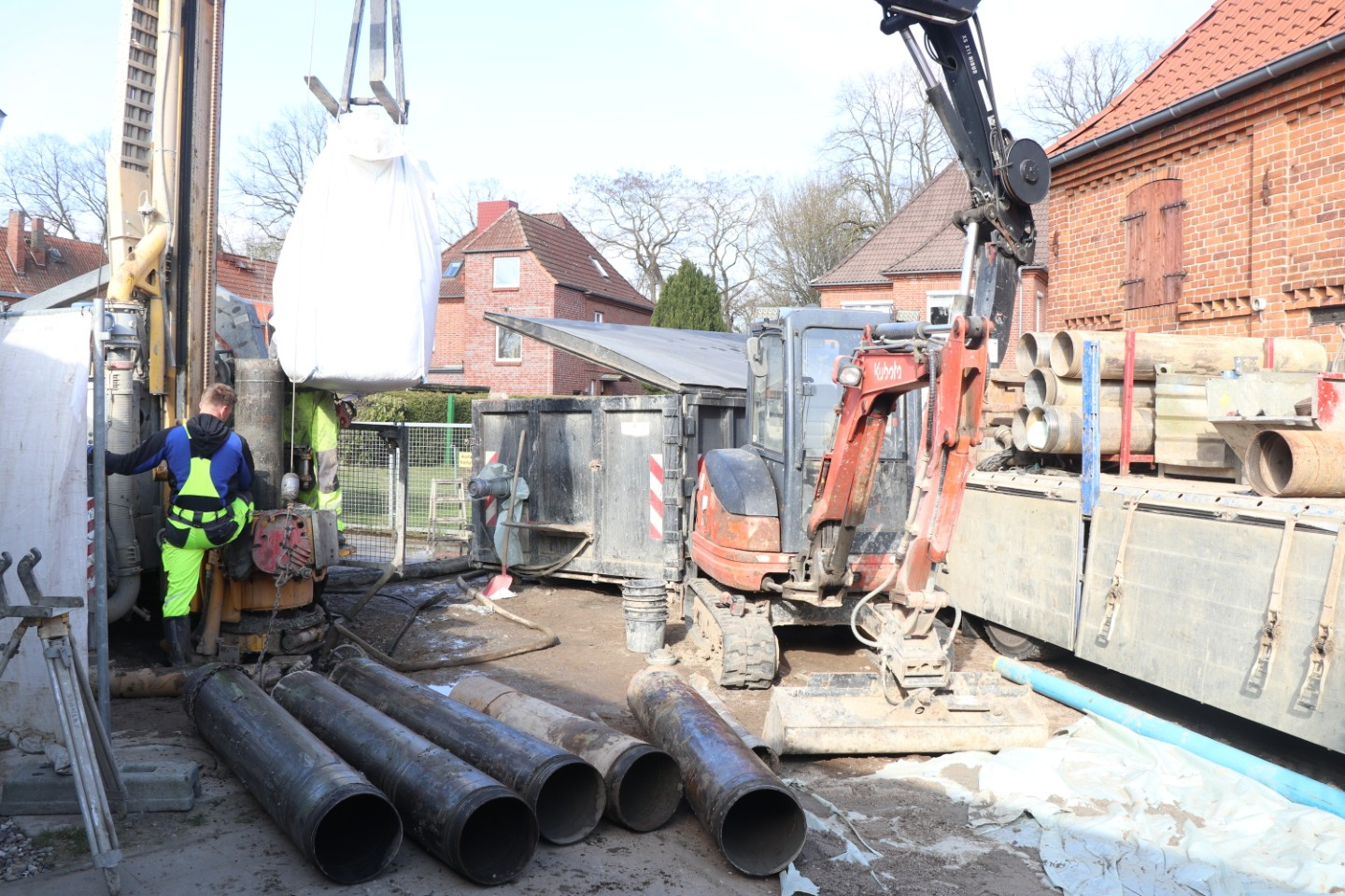 Bagger und Rohre für Baubeginn einer Grundwassermessstelle